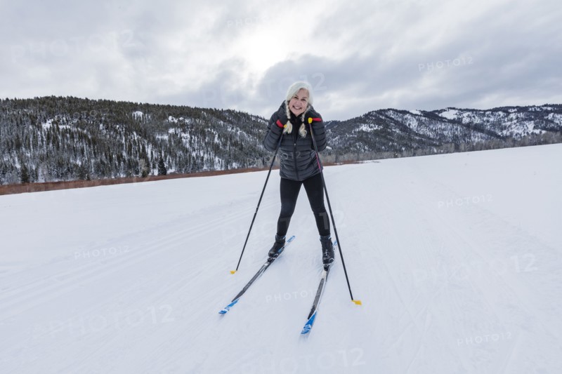 Portrait of senior woman cross - country skiing on groomed trails