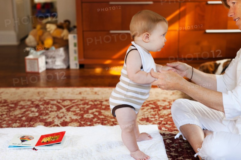 Mother and baby son playing on carpet