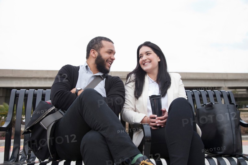 Young couple sitting on bench on platform