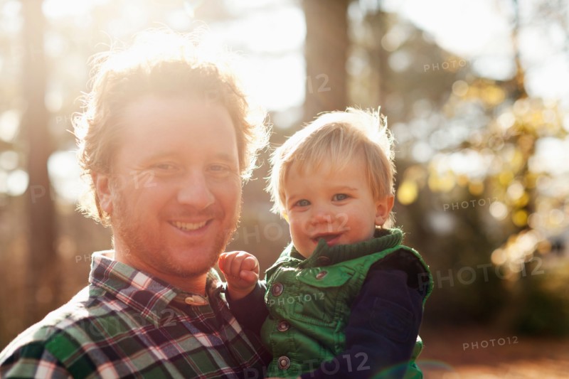 Father holding son in park