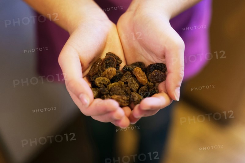 Cupped hands holding raisins