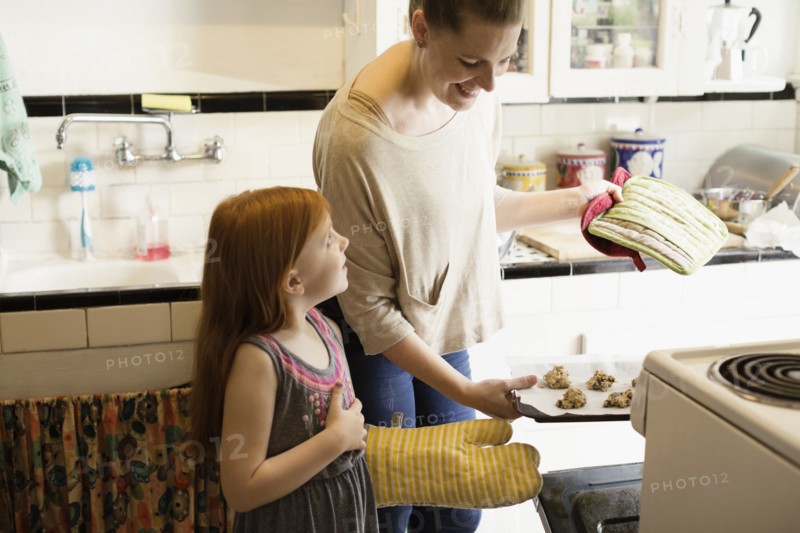 Girl and mid adult mother baking biscuits