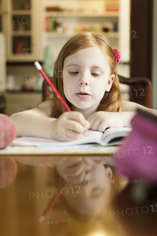 Girl doing school homework at dining room table