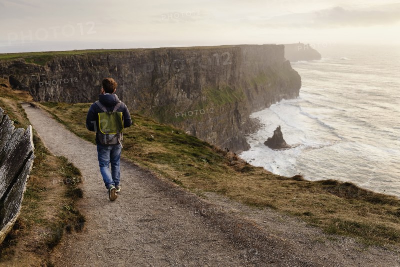Mid adult man walking on The Cliffs of Moher