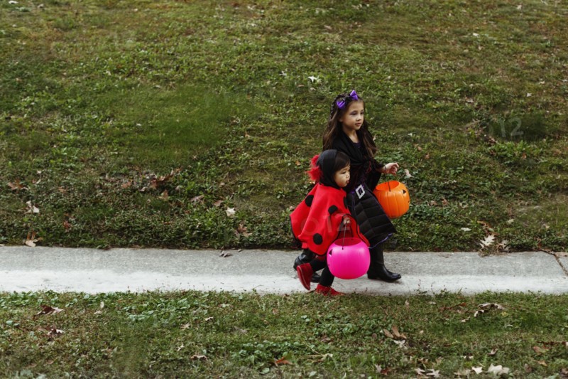 Two girls in fancy dress costumes walking down path