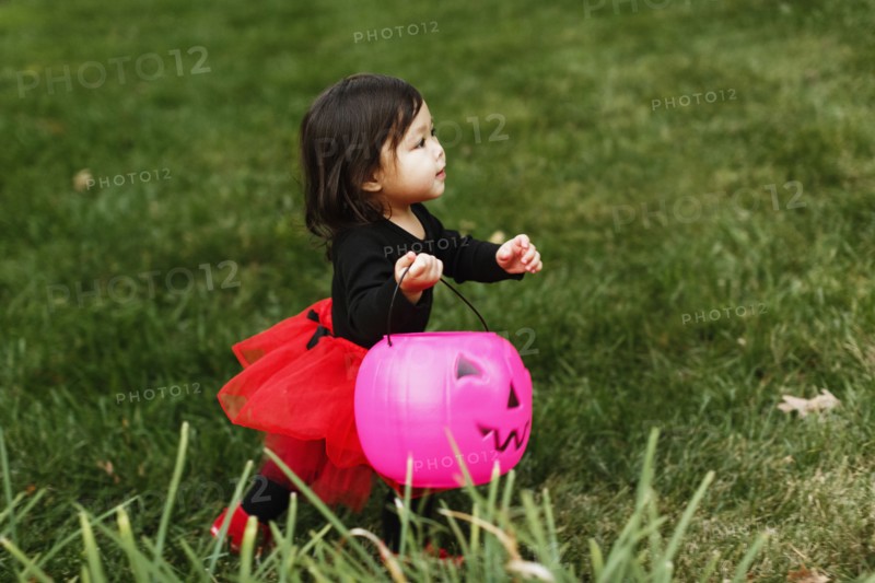 Girl in fancy dress costume with trick or treat bucket
