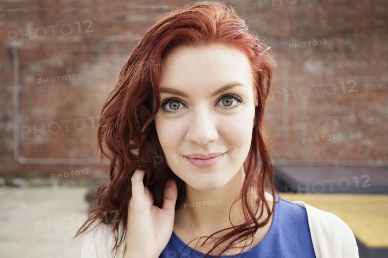 Portrait of young woman with long red hair