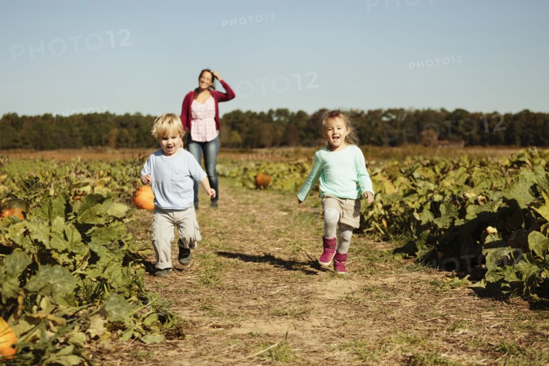 Mother with two children in pumpkin field