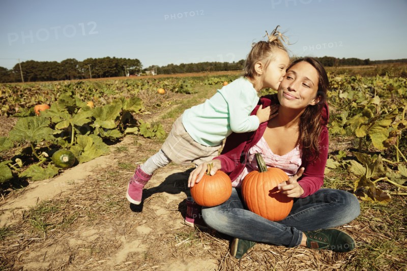 Mother and daughter in pumpkin field