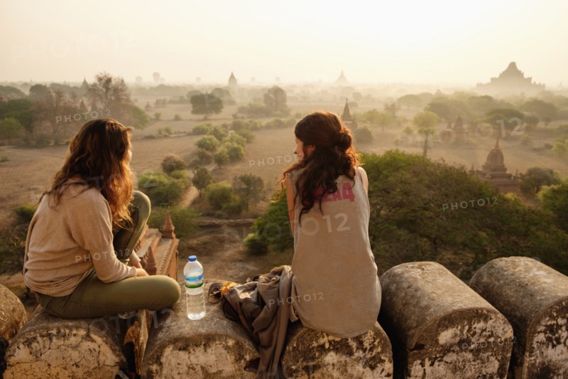 Women relaxing on stone wall