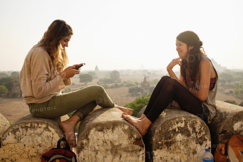Women relaxing on stone wall