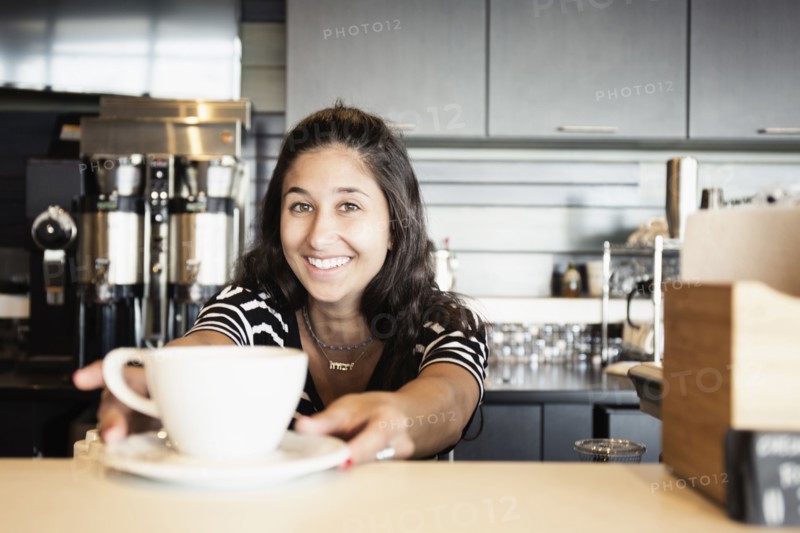 Coffee shop barista serving coffee