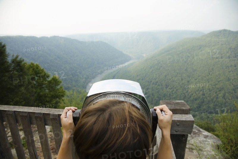 Mid adult woman looking through coin operated binoculars