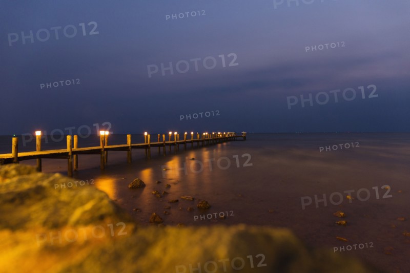 View of sea and pier at night