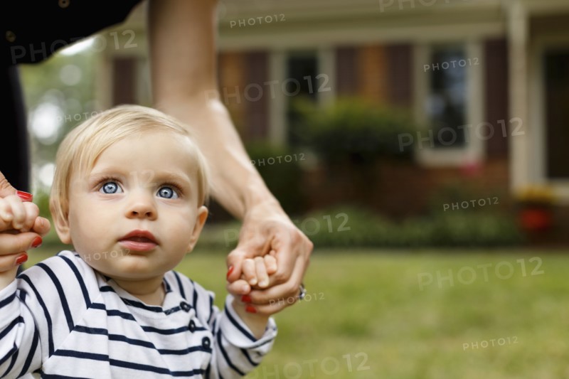 Mother holding baby girl's hands