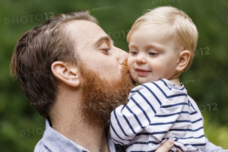 Portrait of father kissing baby girl