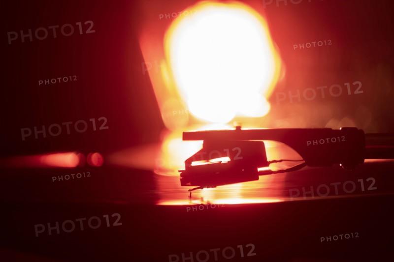 Close-up of a record player needle on record in orange light