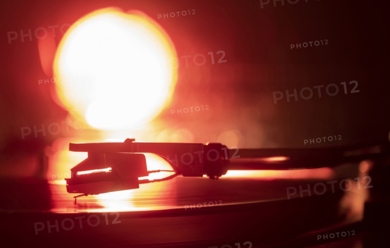 Close-up of a record player needle on record in orange light