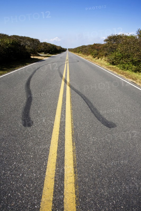 Tire tracks and double yellow line on empty road