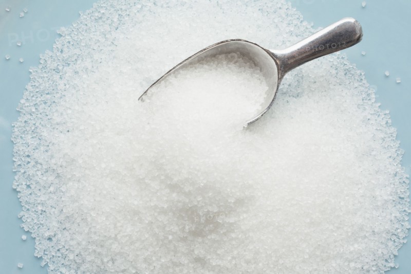 Studio shot of heap of sugar and scoop