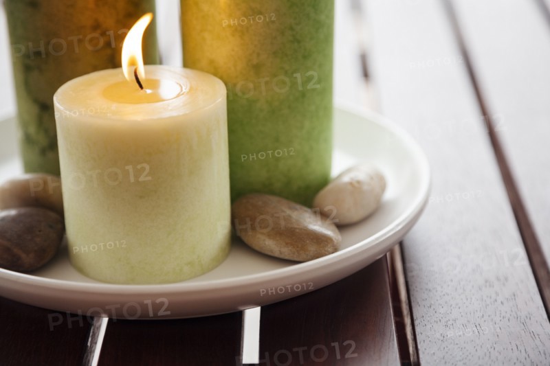 Close-up of candles and stones on plate