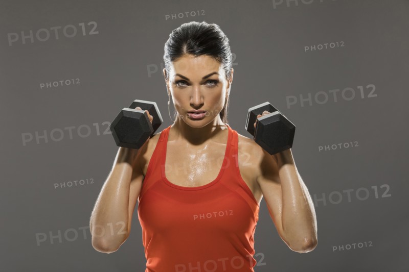 Studio portrait of woman exercising with dumbbells