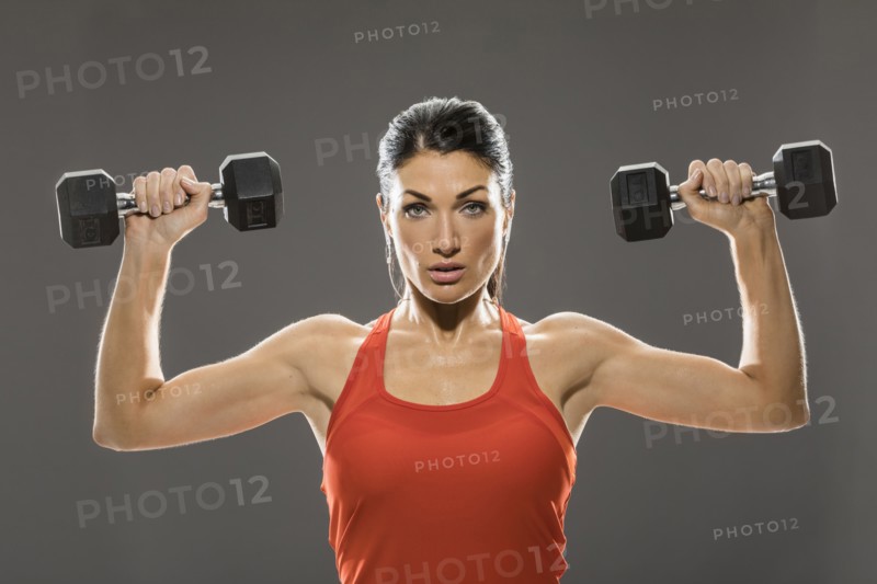 Studio portrait of woman exercising with dumbbells