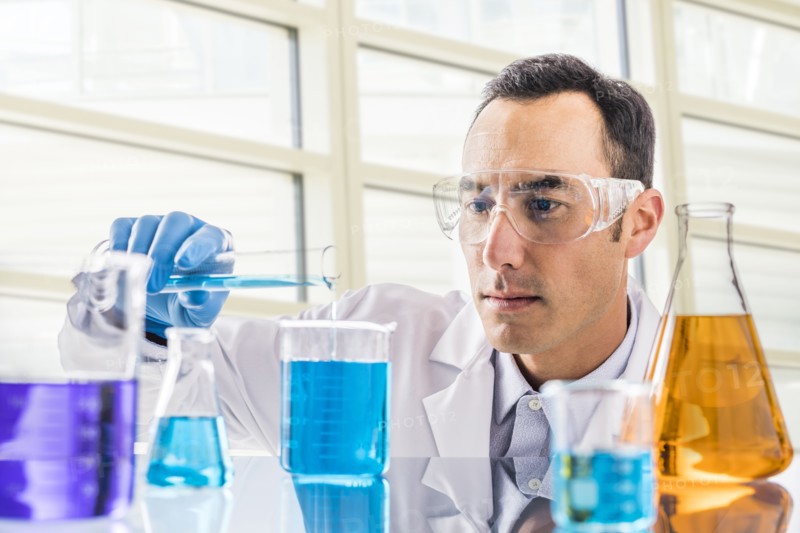 Scientist pouring blue liquid in laboratory