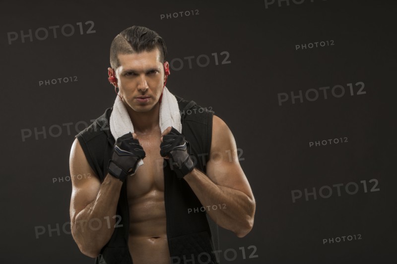 Portrait of muscular man wearing sports gloves