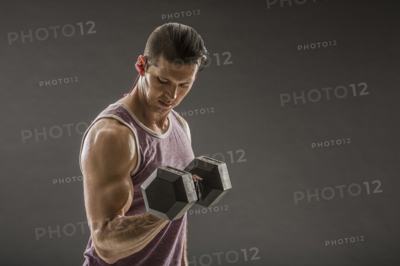 Muscular man doing bicep curl with dumbbell