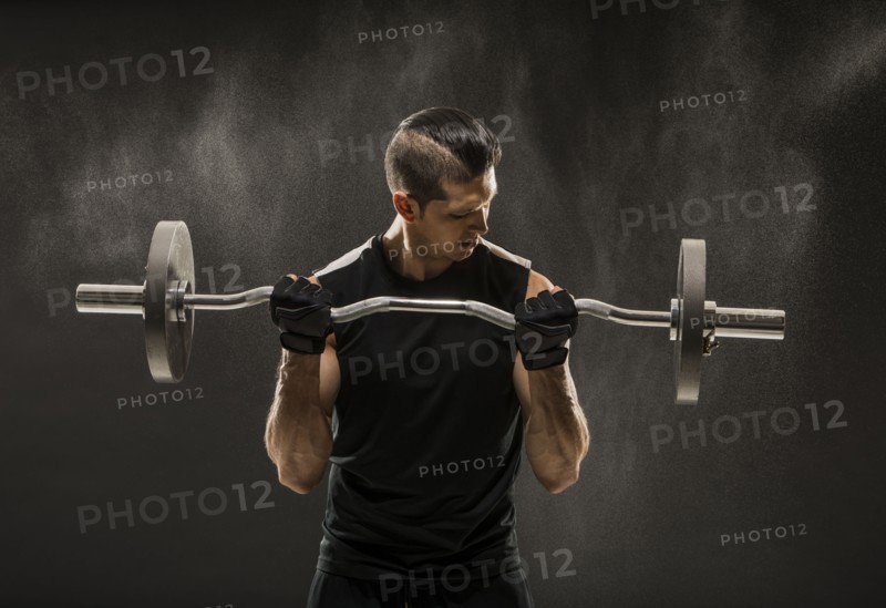 Muscular man training with barbell
