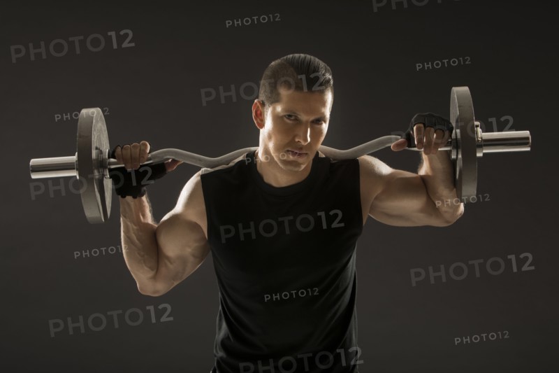 Muscular man training with barbell
