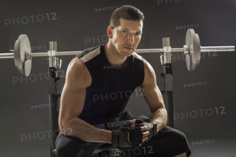 Muscular man training with barbell