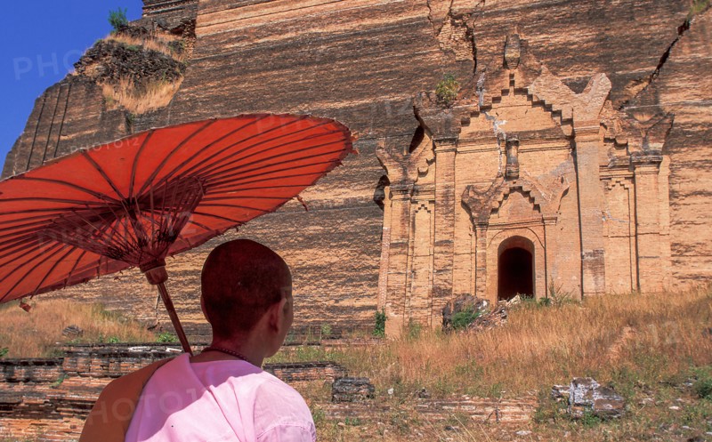 Buddhist nun in front of old Buddhist temple ruined by earthquake