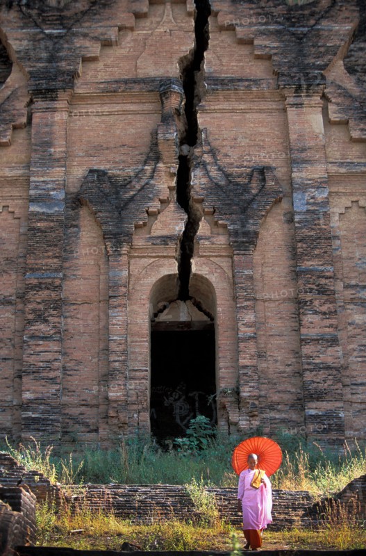 Buddhist nun in front of old Buddhist temple ruined by earthquake