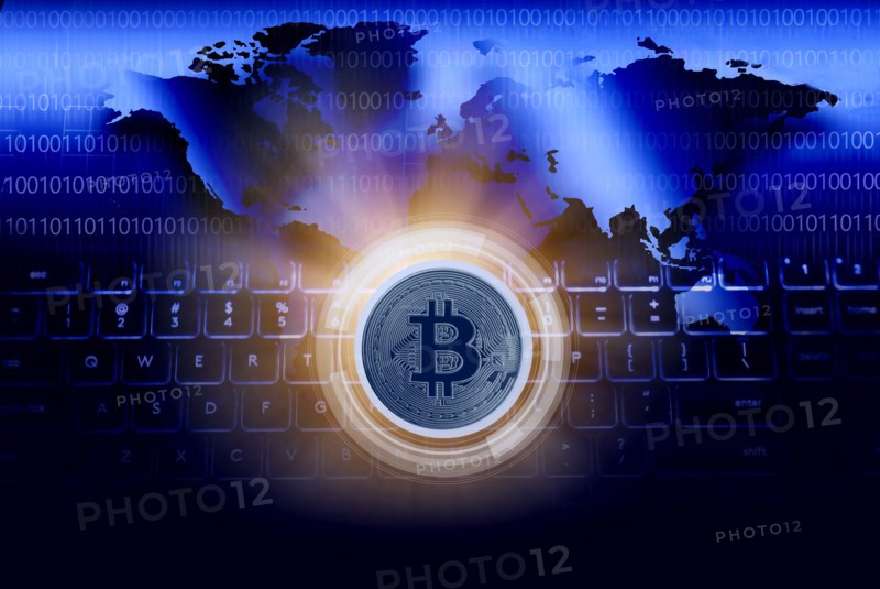 Bitcoin against World map and computer keyboard