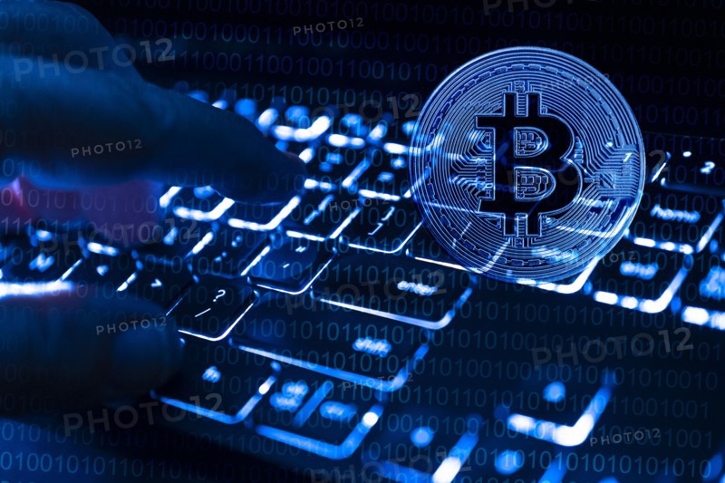 Fingers at computer keyboard and bitcoin