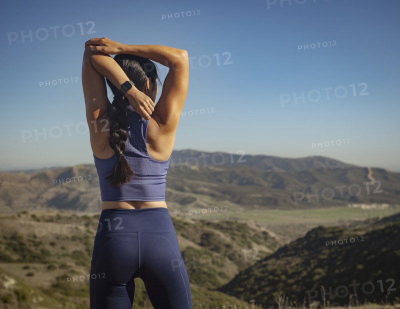 Rear view of woman stretching in landscape