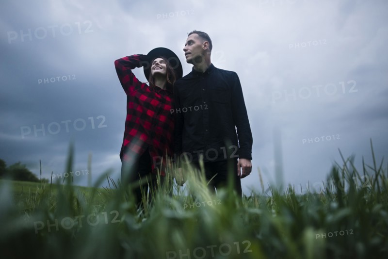 Young couple wrapped in wheat field on overcast day