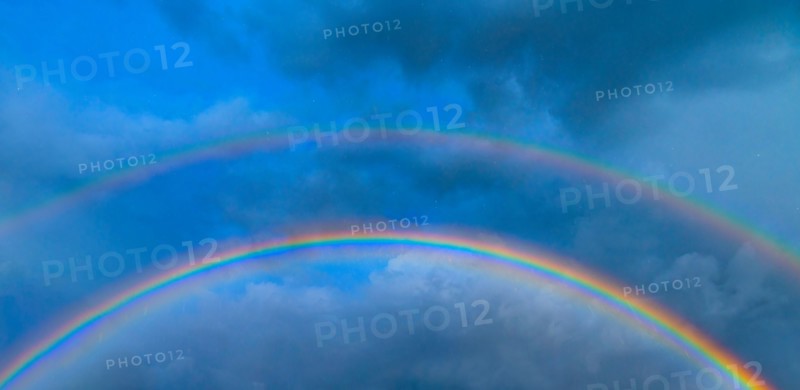 Double rainbow against stormy sky