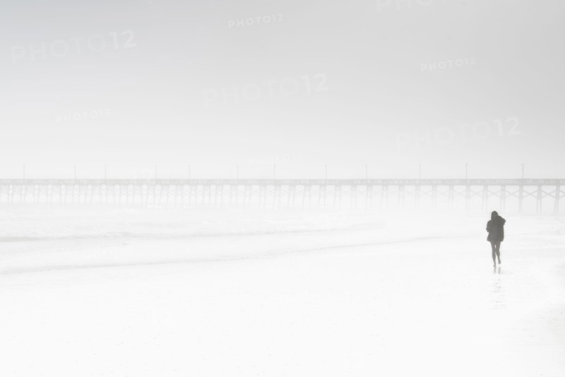 Usa, North Carolina, Surf City, Woman walking on misty beach