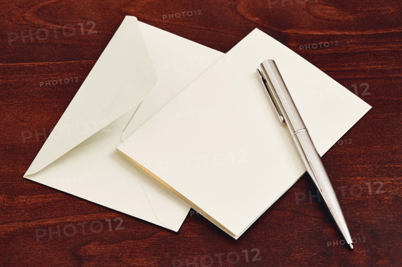 Envelope and pen on wooden table