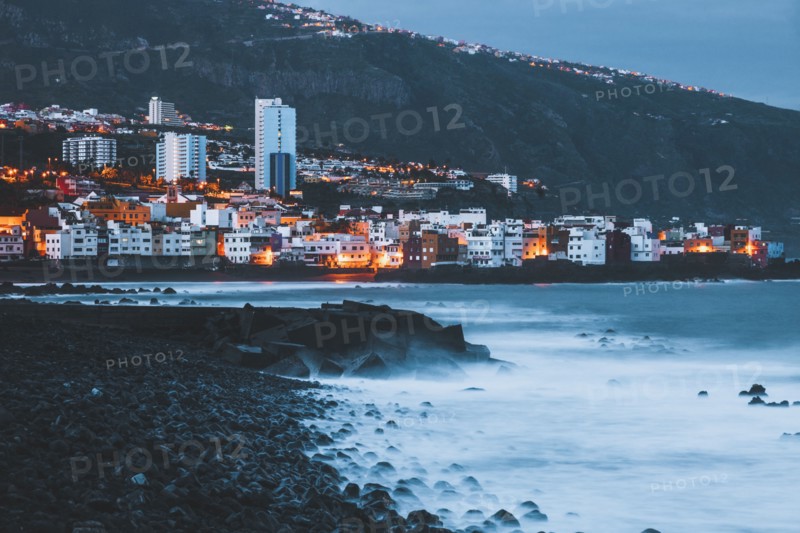 Spain, Canary Islands, Tenerife, Puerto De La Cruz, Buildings on sea coast at dusk