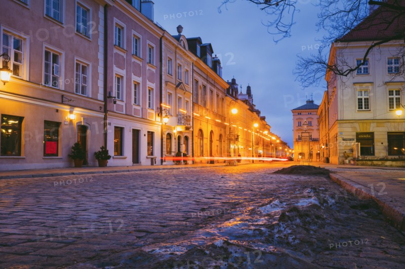 Poland, Masovia, Warsaw, Townhouses along cobblestone street in old town at night