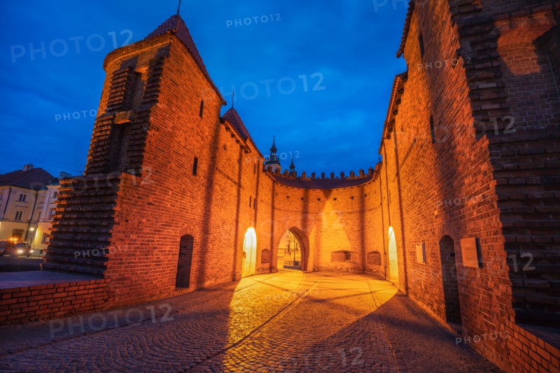 Poland, Masovia, Warsaw, Old City walls and barbican illuminated at night