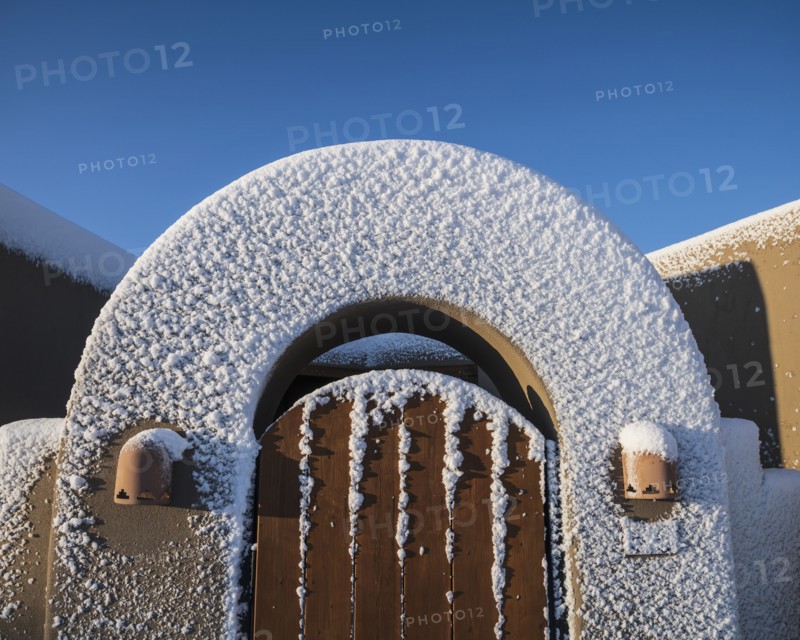 Usa, New Mexico, Santa Fe, Gate to Adobe style house covered with snow in winter