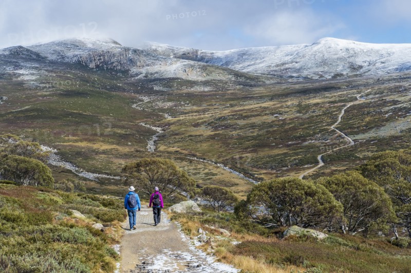 Australia, New South Wales, Two people hiking on trail at Charlotte Pass in Kosciuszko National Park