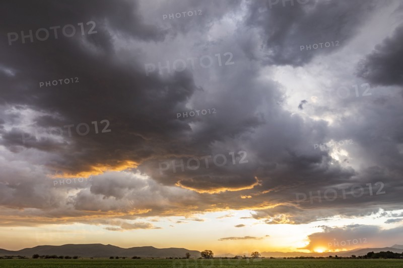 Usa, Idaho, Bellevue, Storm clouds over fields at sunset