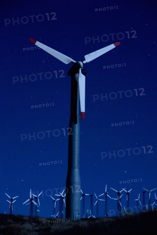 Wind turbines in landscape at night