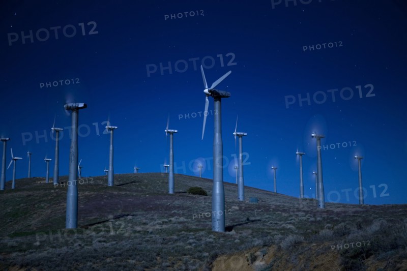 Wind turbines in landscape at night